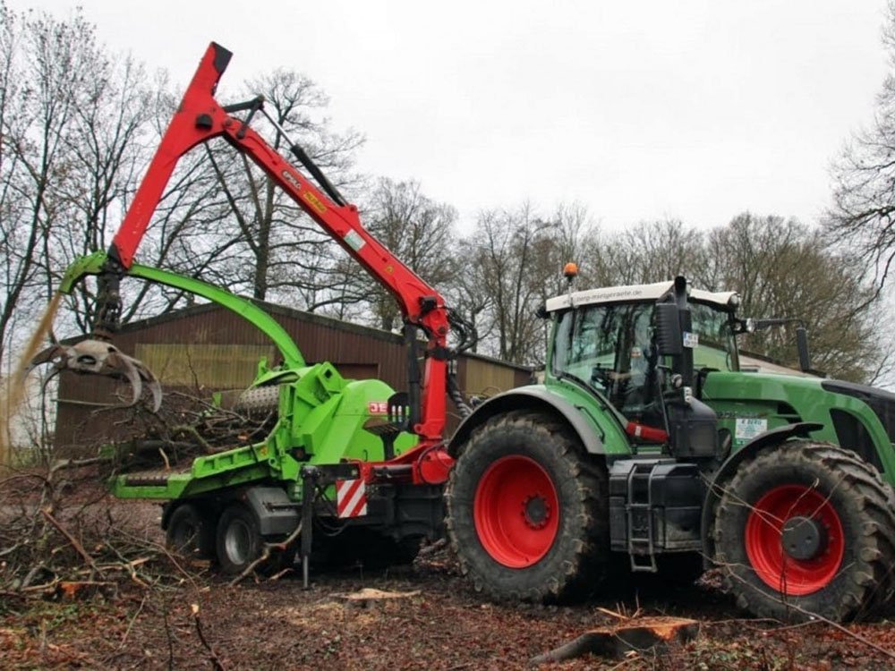Holzhäckseln mit moderner Forsttechnik Traktor mit Holzhäcksler bei Forst- und Häckselarbeiten